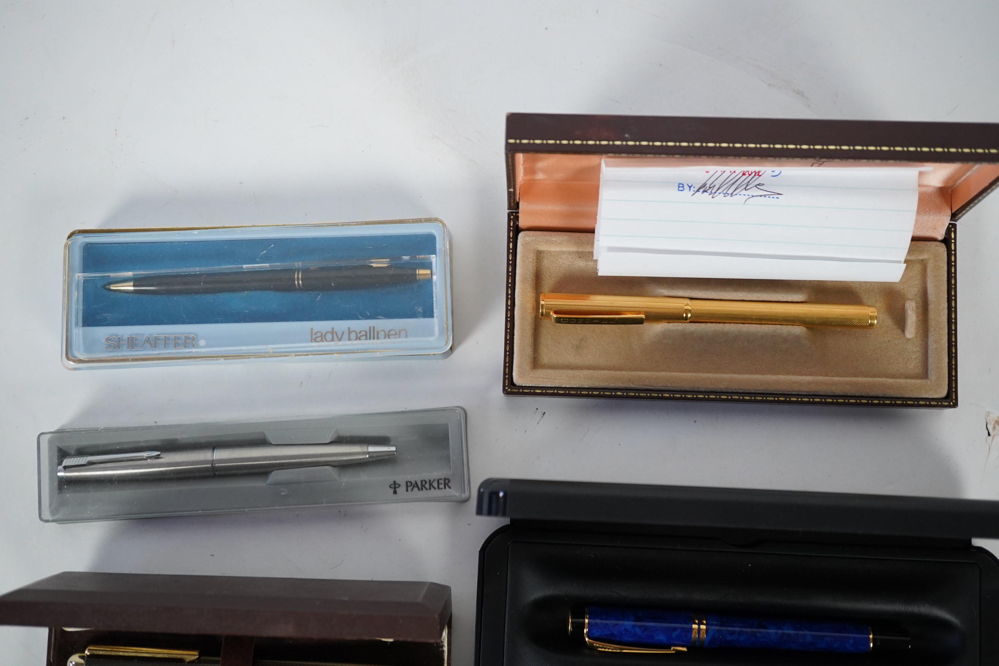 A cased Parker duofold ballpoint pen, a cased Parker Sonnet lacquer ruby red fountain pen, a Dunhill gold plated fountain pen and various fountain pens and ballpoint pens including Parker, Sheaffer, Quill, etc.